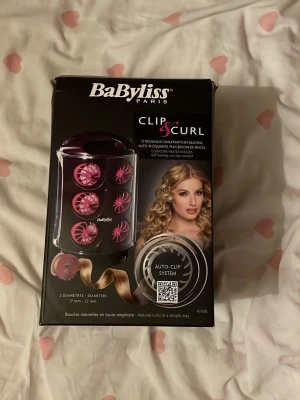 BaByliss Clip & Curl värmespolar - BaByliss Clip & Curl är ett set med 12 värmespolar i silikon för att enkelt skapa naturliga lockar. Spolarna har två olika diametrar, 17 mm och 22 mm, och är självfästande så du slipper klämmor. Perfekt för dig som vill fixa snygga lockar snabbt hemma.