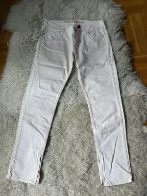 Ljusrosa skinny jeans från Guess - Säljer ett par ljusrosa skinny jeans från Guess med klassisk femficksdesign och dragkedja vid benslut. Jeansen har låg midja och är tillverkade i stretchigt denim för en bekväm passform. Perfekta för dig som gillar en stilren och trendig look.