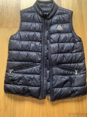  Moncler väst GUI - Mörkblå moncler väst i bra skick. Passar ungefär 155-164cm. Helt äkta skriv privat för bevis.