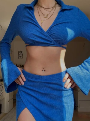Long sleeve top & mini slit skirt set size XS/S - Mycket bra skick, köpt utomlands. Matchande tvådelat set med en croppad långärmad topp och en figurnära minikjol med slits upp längs låret. Väldigt smickrande passform som följer kroppen fint. Mjukt och stretchigt material som är bekvämt samtidigt som det ser uppklätt ut. Lätt att styla med klackar och smycken för en chic feminin look. Storlek XS/S. ❤️ Very good condition. Matching two-piece set with a cropped long sleeve top and a fitted mini skirt with a thigh slit. 