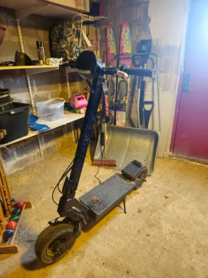 Svart elscooter KuKirin med display - Elektrisk scooter från KuKirin i svart med digital display som visar hastighet, batterinivå och körläge. Scootern har bred fotplatta, stora hjul och handtag med reglage. Perfekt för smidig transport i stan.