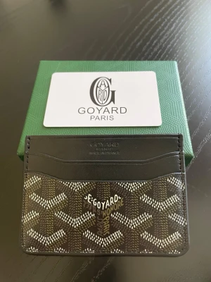 Coffee black kortfodral från Go4yard  - Stilrent svart kortfodral från Go4yard med klassiskt mönster i vitt och grått. Fodralet har flera kortfack och är tillverkat i läder och canvas. Perfekt för dig som vill ha en exklusiv accessoar med ikonisk design från Paris.