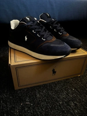 Mörkblå sneakers från Polo Ralph Lauren - Säljer dessa riktigt snygga Ralph Lauren sneakers! Skorna är i mocka med lite gummidetaljer. Riktigt sköna att gå i och perfekta inför sommaren!☀️ Skorna är använda någon enstaka gång så de är nästan nyskick, det ända på de kan vara lite smuts men inga defekter eller trasigt!! Storlek 44. Hör av er vid frågor👏🙌