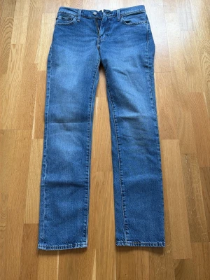 Blå raka jeans från Levi's Premium - Säljer ett par klassiska blå jeans från Levi's Premium med rak passform. Jeansen har normal midja och är gjorda i slitstark denim. Perfekta för en avslappnad och tidlös stil. Använd endast 2 gånger. Modell: Slim