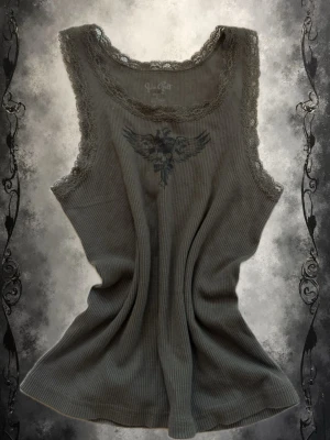 Olivgrön ribbad linnetopp med spets - Säljer en olivgrön ribbad linnetopp. Toppen har spetsdetaljer runt halsringning och ärmhål samt ett tryckt motiv framtill. Perfekt för dig som gillar edgy och feminina detaljer.