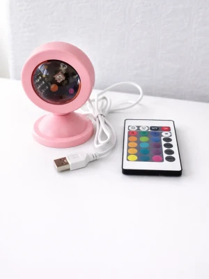 Rosa LED-lampa med fjärrkontroll - Cool rosa LED-lampa med rund form och USB-kabel. Lampan har flera färgval och styrs enkelt med medföljande fjärrkontroll. Perfekt för att skapa stämning i rummet med olika ljuseffekter. Tillverkad i plast och passar på skrivbord eller hylla.perfekt för bilder och video för influensers:).