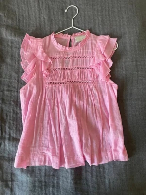 Rosa volangblus från Neo Noir - Supersöt rosa blus från Neo Noir med volangdetaljer på ärmarna. Blusen ser nästan helt oanvänd ut och är i en så fin färg. Köpt för 699 och finns inte att hitta längre. Perfekt för vår och sommar!