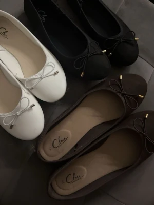Ballerinaskor i vitt, svart och brunt - Säljer klassiska ballerinaskor från Chic i färgerna vitt, svart och brunt. Skorna har rund tå, dekorativ rosett framtill med metalländar och en stilren design. Perfekta för dig som gillar enkel och tidlös stil. Materialet ser ut att vara konstläder. Inget prut vita o bruna andända en gång svarta aldrig andvänt, alla tre säljs tsm