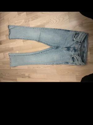 Ljusblå raka jeans från Hollister - Säljer ett par ljusblå jeans från Hollister med rak passform och klassisk femficksdesign. Jeansen har hög midja och är tillverkade i denim med en snygg tvättad look. Perfekta för en avslappnad och trendig stil.