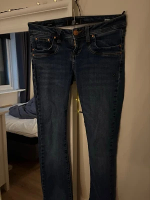 Mörkblå skinny jeans från LTB - Snygga mörkblå boot cut jeans från LTB💕 Jeansen har orangea sömmar och en knappgylf. Tyvärr har dem ett litet hål vid bakre fickan som ni ser på de sista två bilderna. De är i storlek W24 L30💕