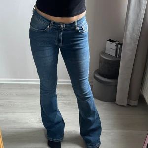 Blå bootcut jeans från Gina Tricot  - Blå bootcut jeans med medel midja och fem fickor. Köpta från Gina Tricot och använda några gånger. Storlek 34 men materialet är stretchigt och kan töjas. Lite slitna vid benen då de är för långa på mig, men annars i fint skick! 
