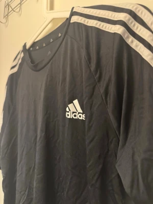 Adidas t-shirt svart – strl L – snygg & klassisk - Svart Adidas t-shirt i storlek L med klassiska tre ränder – enkel, stilren och passar till allt. I bra skick. Säljes pga används inte. Kan hämtas eller skickas (köparen står för frakt) 