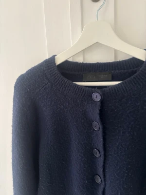 Mörkblå kofta från Zara - Mysig mörkblå kofta från Zara med rund halsringning och stora matchande knappar framtill. Koftan har lång ärm och är stickad i ett fluffigt material🩷