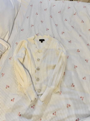 Lipsy vit stickad kofta med silver - Vit stickad kofta från märket lipat storlek 34/XS. Silver/kristall knappar. Så vacker🫶🏼Nypris 750kr. Mitt pris: 150kr