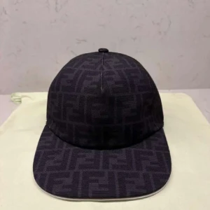 Svart keps med Fendi-logga - Snygg svart keps från Fendi med klassiskt FF-monogram över hela kepsen. Kepsen har böjd skärm och är tillverkad i ett tygmaterial som ger en exklusiv känsla. Perfekt accessoar för att lyfta din streetwear-look.