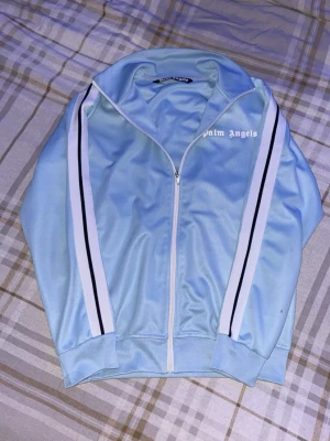 Ljusblå ziptröja från Palm Angels - Riktigt fet zip från Palm angels pytte liten fläck. Hör av dig vid frågor pris ej hugget i sten!