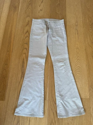 Beiga utsvängda jeans från MiH med fickor fram - Säljer ett par snygga beiga jeans från MiH Jeans med utsvängda ben och klassisk passform. Jeansen har hällor för skärp och diskreta fickor fram. Perfekta för dig som gillar retrovibbar och vill ha ett par stilrena jeans i garderoben. Storlek w26, modell casablanca midwaist flare