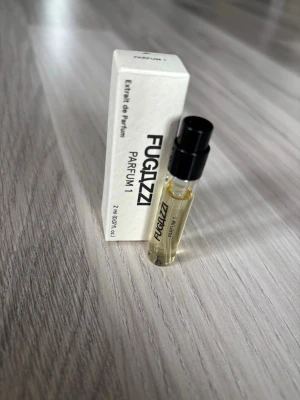 Fugazzi Parfum 1 Extrait de Parfum - Fugazzi Parfum 1 Extrait de Parfum i en liten provflaska på 2 ml. TOP NOTES  Fresh Citrus / Blackcurrant / Spearmint / Satsuma Mandarin MIDDLE NOTES  Davana / Oliban / Orange Blossom / Pink Peppers BASE NOTES  Patchouli / Musk / Australian Sandalwood / Cedarwood