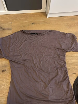 Brun t-shirt från 157 - En enkel brun t-shirt från 157 i storlek XL. T-shirten har korta ärmar och en rak passform, perfekt för en avslappnad stil. Tillverkad i mjukt material som känns skönt mot huden.Varan har inte kommit till användning 