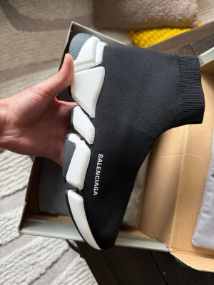 Balenciaga Speed Trainer svarta sneakers - Svarta Balenciaga Speed Trainer sneakers med vit chunky sula och stickad ovandel i textil. Strumpliknande passform och tydlig Balenciaga-logga på sidan. Snygg och futuristisk design som sticker ut.