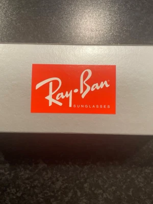 Ray-Ban Havana solglasögon brun - Oöppnad Säljer ett par Ray-Ban solglasögon i modellen Havana med bruna, gradientfärgade glas. Bågarna har en klassisk rektangulär form och är i en brun ton. Perfekta för dig som vill ha en tidlös och snygg accessoar till sommaren.