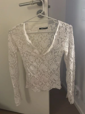 Vit spetsblus från Gina Tricot - Superfin vit spetsblus från gina. V-ringad och är helt täckt av spetsmönster. Relativt använd men känns och syns knappt.