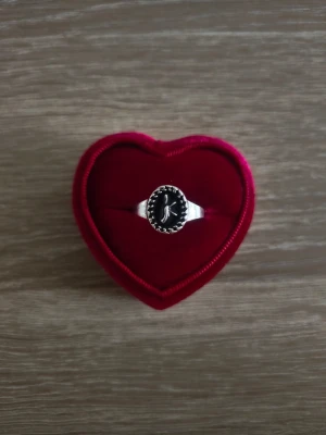Silverfärgad ring med svart oval sten - ring i storlek 19,4mm, silverfärgad. 