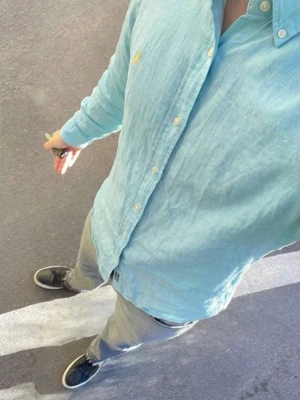 Ljusblå skjorta från Ralph Lauren - Snygg ljusblå skjorta från Ralph Lauren med klassisk button-down krage och broderad logga på bröstet. Skjortan har långa ärmar, knappar framtill och är tillverkad i ett tunt, luftigt bomullstyg. Perfekt för en avslappnad men stilren look. Skjortan är i storlek large. Har en liten defekt se sista bilden! Fråga vid funderingar, priset är diskutabelt🙂