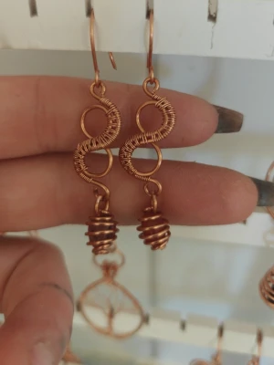 Örhängen i ren koppar, halvädelsten 🌀 - Unika örhängen i koppartråd med spiralformade detaljer. Designen har två sammanlänkade åttor och en spiral längst ner som ger ett coolt och kreativt intryck. Perfekta för dig som gillar handgjorda accessoarer med boho-vibe.