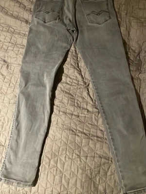 Gråa slim fit jeans från Replay - Säljer ett par gråa slim fit jeans från Replay med klassisk femficksdesign och snygga detaljer på bakfickorna. Jeansen har raka ben. Perfekta för en avslappnad och trendig look. W30 L32