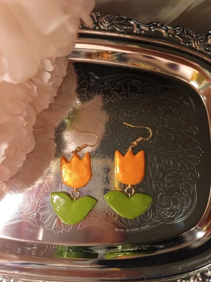 Tulpan örhängen - Handgjorda örhängen med tulpaner. Blomman är schimrig  One of a kind Denna är Handgjord av lera därav priset. Om intresse fins kan jag göra flera