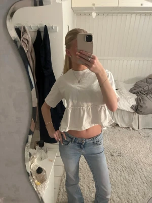 Vit volangblus med kort ärm - Säljer en söt vit blus med volang nertill och korta ärmar. Från Gina tricot, nästan aldrig använd i storlek xs 🥰