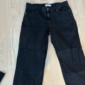 Svarta raka jeans från Stockh lm - Säljer ett par svarta jeans från Stockh lm med rak passform. tillverkade i ett kraftigt denimtyg. Perfekta för en avslappnad och stilren look.