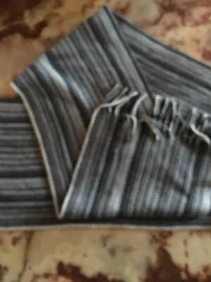 Randig svartvit halsduk i akryl - Snygg halsduk med svartvita ränder och fransar i ändarna. Tillverkad i 100% akryl vilket gör den mjuk och lätt att tvätta. Perfekt accessoar för att lyfta din outfit med en klassisk look.