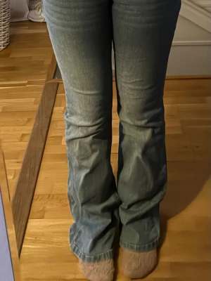 Blå bootcut jeans med fickor - Säljer ett par ljusblå bootcut jeans med klassiska fem fickor och knappgylf. Jeansen har en lätt utsvängd passform nedtill och är perfekta för en avslappnad och trendig look. Materialet är mjukt denim som sitter skönt hela dagen. Storkel 34🩷