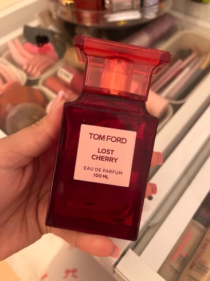 Tom Ford Lost Cherry parfym 100 ml - Tom Ford Lost Cherry Eau de Parfum i en lyxig, mörkröd glasflaska med elegant design. Flaskan rymmer 100 ml och har en fyrkantig form med en bred, röd kork. Doften är känd för sina söta och fruktiga körsbärstoner.