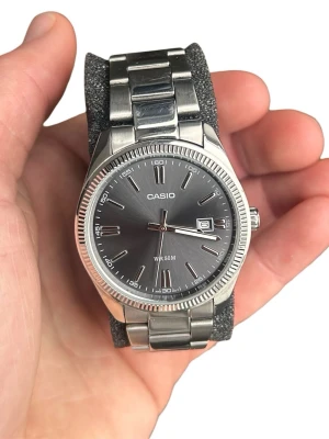 Klassisk silverfärgad Casio klocka - Boett är cirka 38cm. Quartz-urverk. Glaset är i mycket fint skick utan repor. Länken har mindre bruksspår/repor som syns vid nära inspektion, inget som stör vid normal användning. Extra länkar medföljer samt originalbox. Jag postar alltid inom 24h efter köp. Pris kan diskuteras vid snabb affär. Skickas välpaketerad, tveka inte på att höra av dig vid frågor!😊