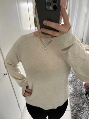 Beige stickad tröja från Vero Moda - Mysig beige stickad tröja från Vero Moda med rund halsringning och ribbade muddar. Tröjan har en enkel och stilren design som passar perfekt till jeans eller kjol. Materialet känns mjukt och bekvämt mot huden.