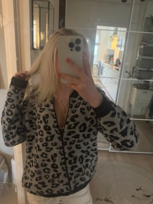 Leopardmönstrad kofta från Gabriella K❤️ - Säljer en snygg kofta med leopardmönster i svart och grått från Gabrielle X. Koftan har dragkedja framtill, ribbade muddar och en avslappnad passform. Perfekt för dig som vill sticka ut med ett djuriskt print. 🐆❤️Är lite nopprig längst ner! Är storlek 40 men passar mig som har S