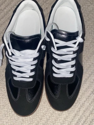 Svarta maison Margielas - Snygga svarta sneakers med vita skosnören och vit insida. Priset kan diskuteras👍
