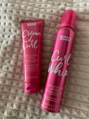 Umberto Giannini Curl Styling Duo (cream och mousse) - Säljer två hårprodukter från Umberto Giannini: Crème de Curl Curl Control Cream och Curl Whip Curl Activating Mousse. Båda är i snygga rosa förpackningar och perfekta för att definiera och framhäva lockar. Passar dig som vill ha återfuktade, frizzfria och skyddade lockar. Moussen är lite sönder men annars påverkar inte alls funktionen (bilder finns).