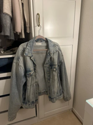 Oversized ljusblå jeansjacka - Säljer en oversized ljusblå jeansjacka från Monki. Klassisk modell med två bröstfickor med lock och knappar framtill. Jackan har en avslappnad passform och nedhasade axlar för en cool, laidback vibe. Jackan är från Ginatricot är i väldigt bra skick🥰kom privat för frågor! 