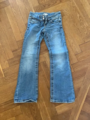 Blå bootcut jeans från Gina Tricot - Säljer ett par ljusblåa jeans från Gina Tricot i storlek 140. 