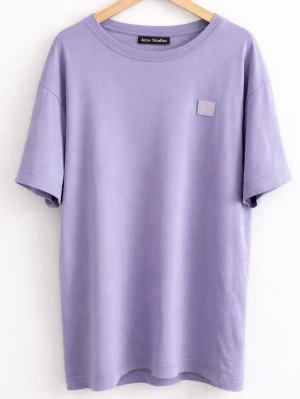 Lila t-shirt från Acne Studios - Säljer en stilren lila t-shirt från Acne Studios med det klassiska ansiktslogotypen på bröstet. Litet hål på T-shirten. Orginalpris: 2700kr