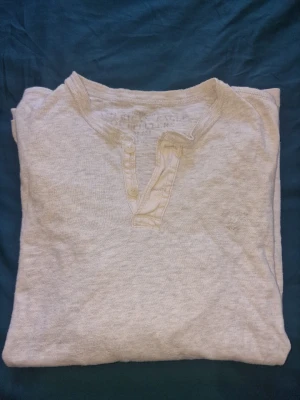 American Eagle långärmad tröja - Långärmad tröja med knappar framtill. Enkel och stilren design som passar till det mesta. Den klassiska logotypen vid bröstet.