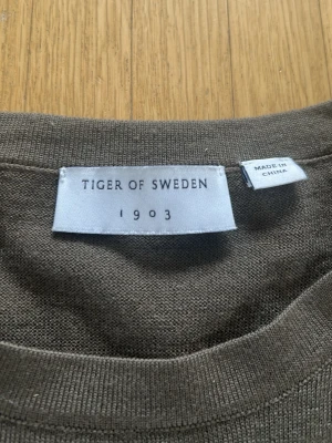 Olivgrön t-shirt från Tiger of Sweden - Snygg olivgrön t-shirt från Tiger of Sweden i modellen CONNOR RWS. Tillverkad i mjuk bomull med klassisk rund hals och korta ärmar. Perfekt för en stilren och enkel look.