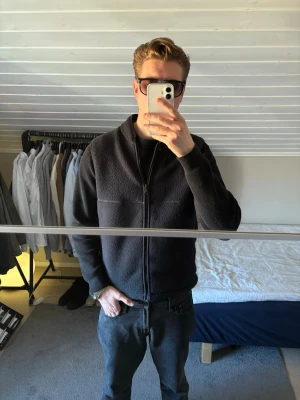 Svart fleeceväst med dragkedja - En enkel och stilren svart fleeceväst med hög krage och hel dragkedja framtill. Västen är gjord i mjukt fleecematerial och har en rak passform som funkar till många olika outfits.