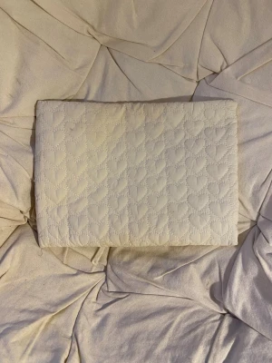 Datorfodral - Fin datorfodral med hjärtan. Den är använd och har tecken på det då den är lite smutsig på vissa ställen. Se bilder. Går säkert att tvätta bort. Längd: 36cm, höjd: 27cm