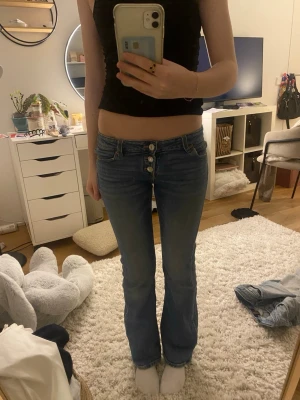 Blå bootcut jeans från Gina  - Snygga blå bootcut jeans i storlek 146 med flera synliga knappar framtill. Jeansen ser lite skinny ut på mig eftersom att de är för små de är utsvängda. Jeansen är en gammal model från Gina tricot. Midjemått 33x2 cm med stretch Innebenslängden 73  cm gren 18 cm💙