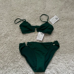 Grön bikini med guldringar  - Grön bikini med snygga guld detaljer. Aldrig använt prislapp är kvar. Säljer pga av lite för liten, men as snygg. 